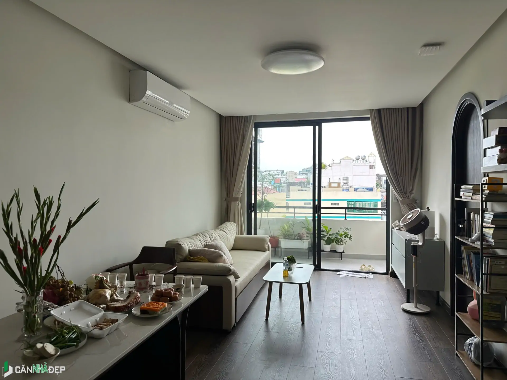 Không gian phòng khách của một căn hộ hiện đại, với điểm nhấn là cửa kính lớn hướng ra ban công. Đây là kiểu bố trí phổ biến trong các căn hộ chung cư nhằm tối ưu ánh sáng và tầm nhìn.